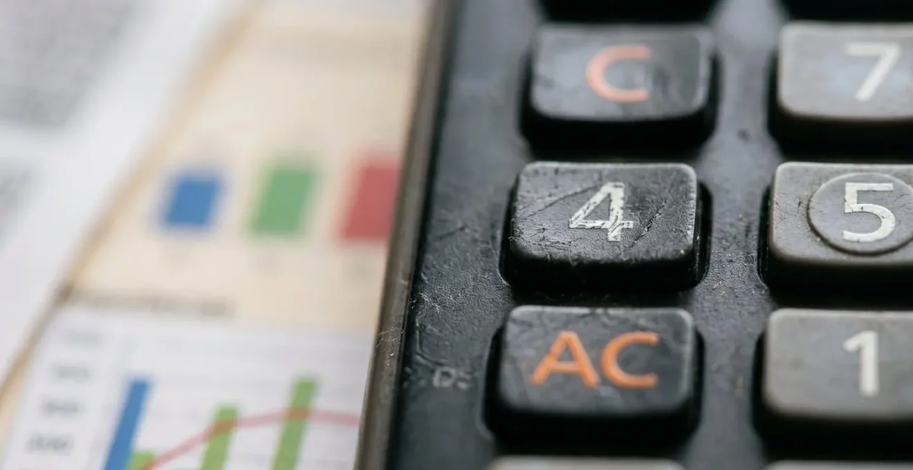 Mesa de trabajo con calculadora y documentos para calcular TAE personalizada